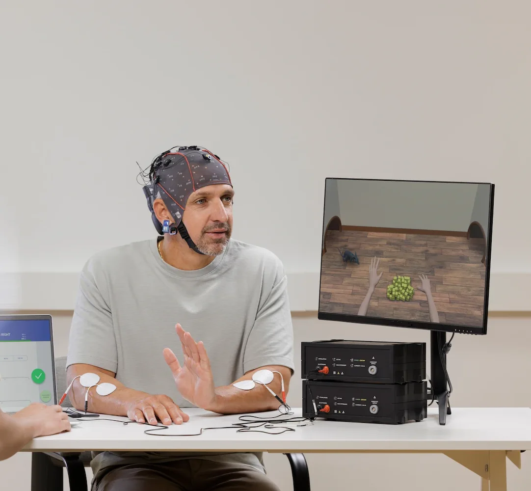 Patient sitzt und macht Rehabilitation am recoveriX