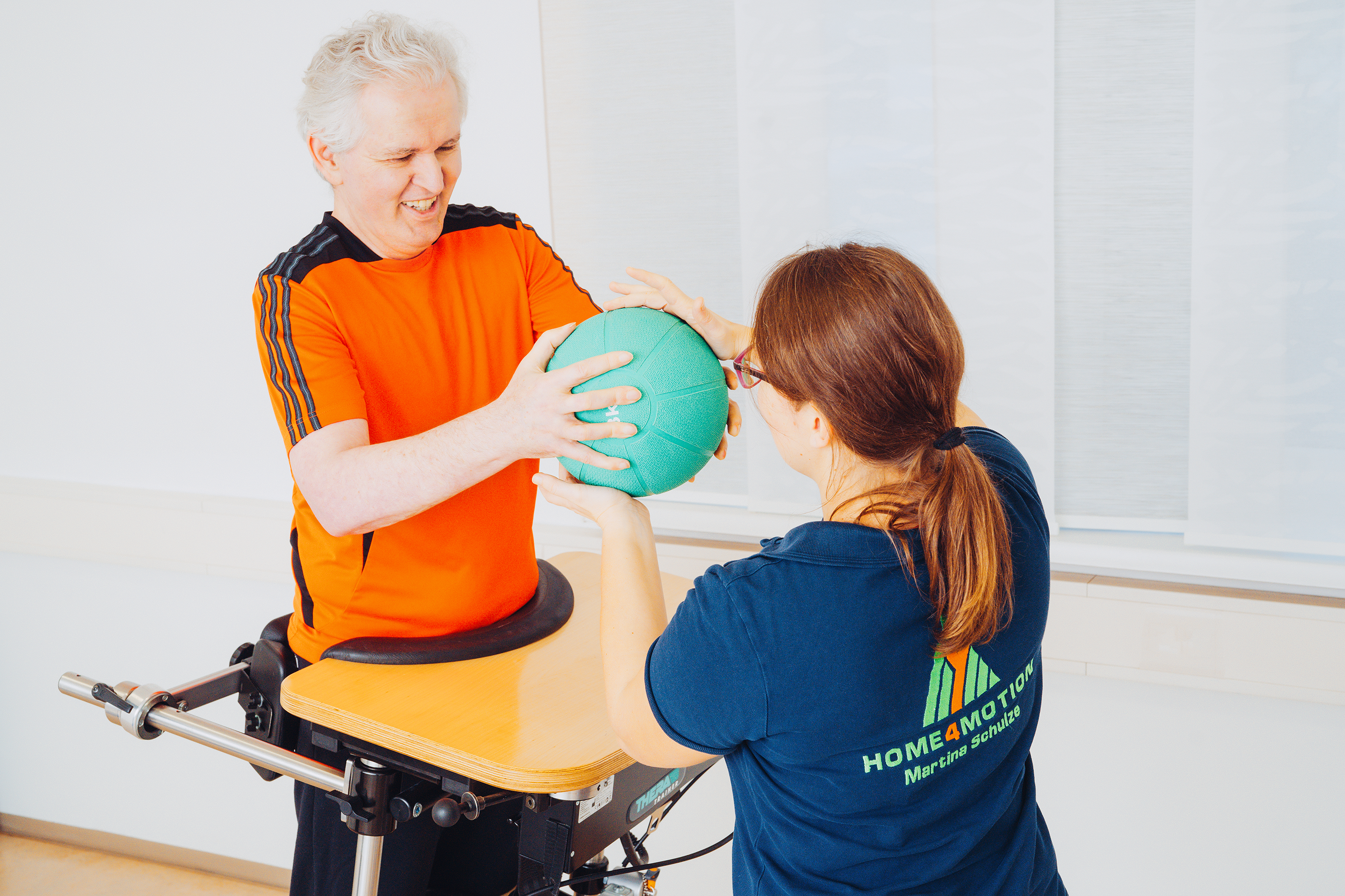 Patient mit dem Ball und Therapeutin hilft