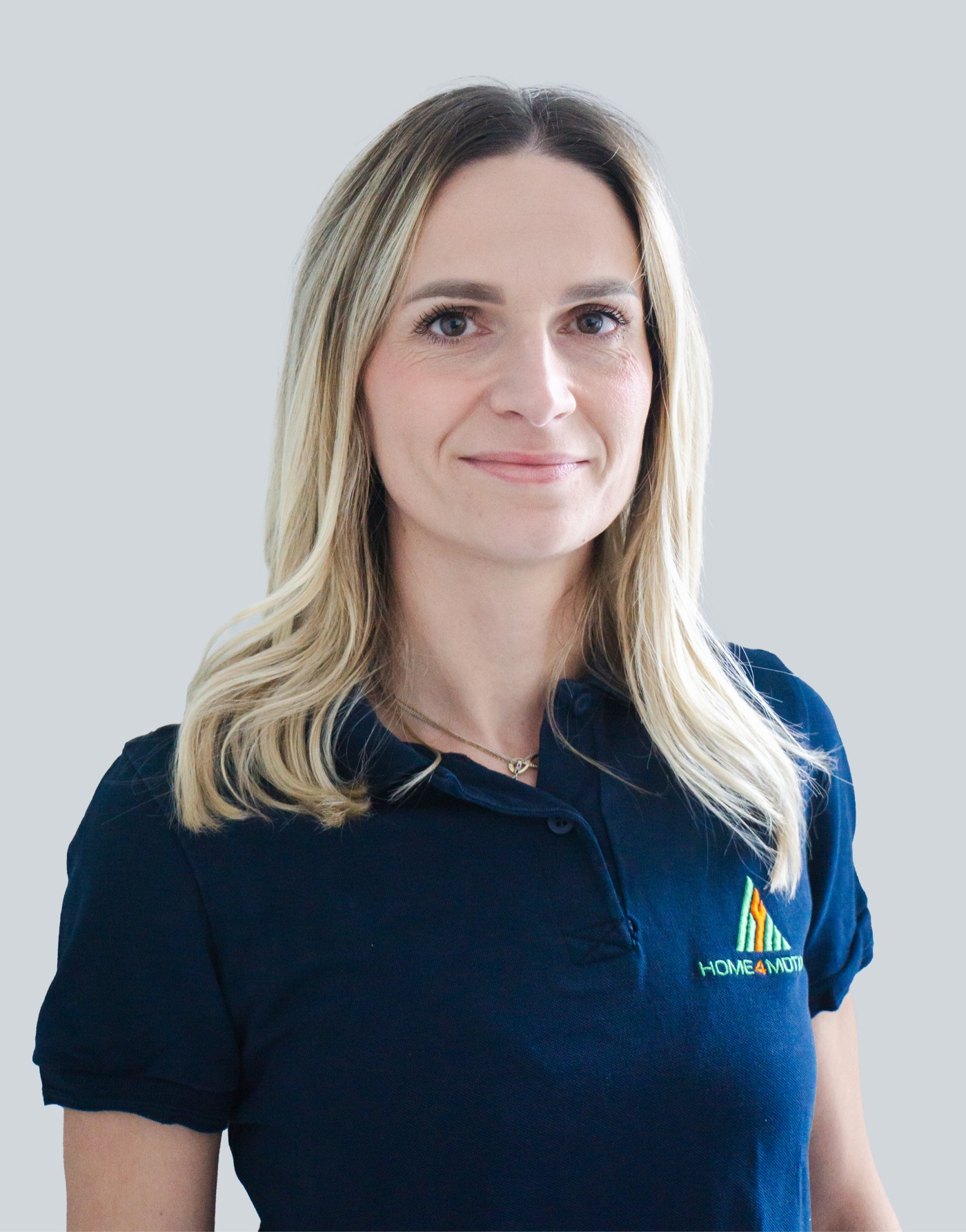 Blonde Frau mit mittellangen Haaren und blauem Polo Tshirt mit HOME4MOTION Logo